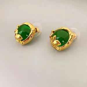 Vintage gold emerald stud earrings with textured irregular metal and green gemstone