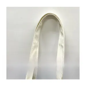Detail of reinforced double-stitched handle on cream canvas bucket shoulder bag