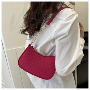 Detail view of pink quilted felt shoulder bag featuring V-shaped stitching and gold chain strap