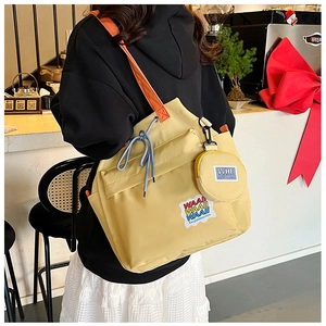 Detail of yellow canvas bucket bag with orange straps and a detachable round coin purse
