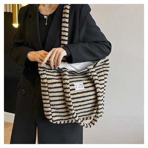Dettaglio di borsa tote in peluche a righe con morbida texture in finta pelliccia