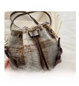 Close-up of vintage plaid wool bucket bag with leather drawstring and texture details