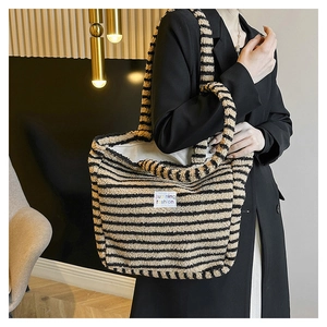 Dettaglio della morbida borsa tote in peluche a righe con patch logo decorativa