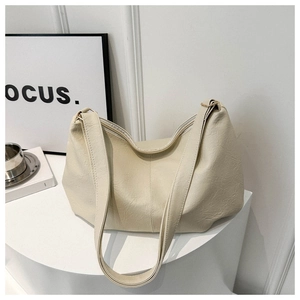 Close-up of cream soft PU leather tote bag with wide strap and zipper closure