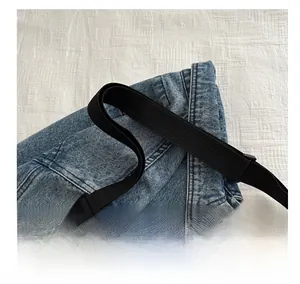 Detail of the comfortable black nylon shoulder strap on a beige canvas tote bag