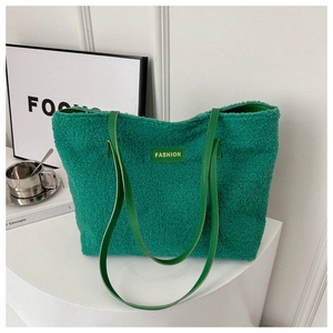 Dettaglio della borsa tote in pile verde con tracolla in pelle ed etichetta moda