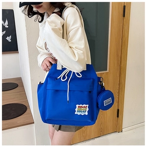 Blue canvas bucket bag with WAA!! patch embroidery and round mini coin purse detail