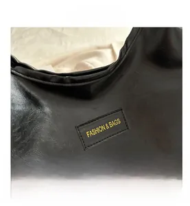 Close-up of black leather texture featuring a Fashion & Bags yellow label on a tote bag