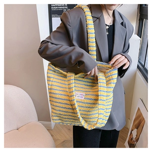 Dettaglio della borsa tote in peluche a righe gialle e blu con texture morbida e tracolla