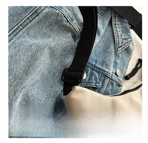 Close-up of adjustable black nylon shoulder strap on a beige canvas tote bag