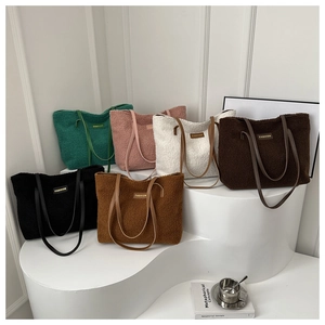 Borse tote in pile in sei colori con spallacci in pelle ed etichetta Fashion su stand bianco