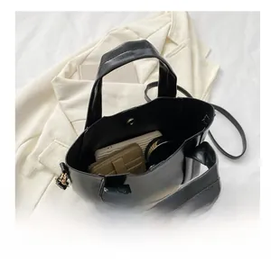 Interior view showing the large capacity of the black leather bucket bag with items