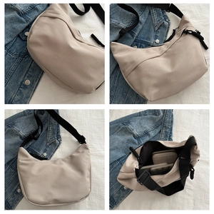 Detail view of beige nylon crescent bag with adjustable wide strap and spacious interior