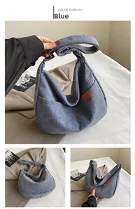 Macro detail of blue corduroy hobo bag with sport leather patch and textured fabric