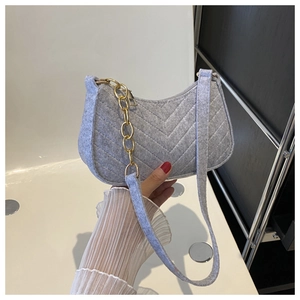 Detail of light gray felt shoulder bag with V-shaped stitching and chunky gold metal chain