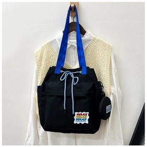 Detail of canvas bucket bag with blue straps and Waaii embroidery in a lifestyle setting
