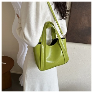 Detail of avocado green tote bag in glossy PU leather with adjustable shoulder strap