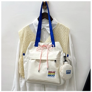 Detail of canvas bucket bag with drawstring closure and small round pendant pouch