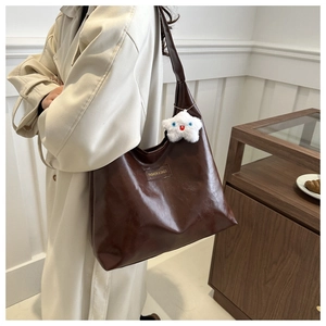 Detalle del bolso tote marrón café con etiqueta de moda y colgante de estrella blanca