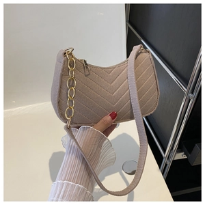 Detail of beige quilted felt shoulder bag with gold chain and chevron texture