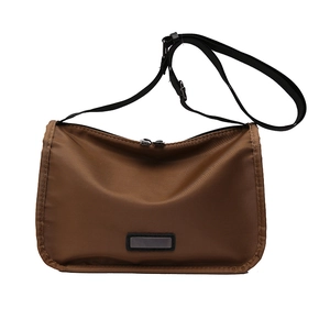 Brown nylon crossbody bag with wide shoulder strap and minimalist pillow design
