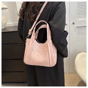 Detail of pink faux leather tote bag showing adjustable strap and soft textured finish