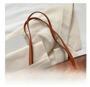 Close-up of the reinforced stitching and vintage brown leather texture on the tote bag