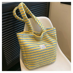 Dettaglio della borsa tote in peluche a righe gialle e blu con morbida texture e etichetta