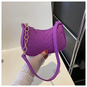 Close-up of purple felt underarm bag featuring V-shaped quilting and gold chain strap