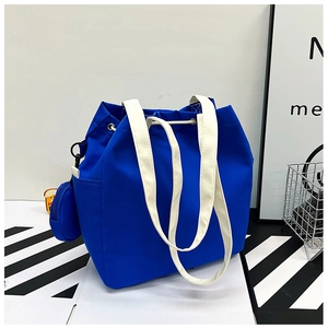 Detail of royal blue canvas bucket bag with cream strap and mini round coin purse