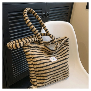 Dettaglio della borsa tote morbida a righe tigrate con texture pelosa e etichetta duoning