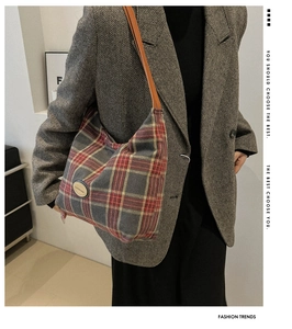 Détail d'un sac hobo vintage à carreaux rouges et jaunes avec bandoulière en cuir souple