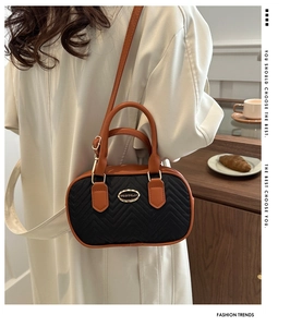 Quilted handbag with orange-brown straps shown in lifestyle setting with a beige coat