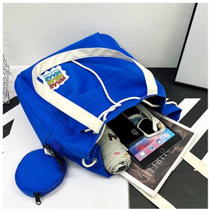 Macro shot showing blue canvas bucket bag capacity with tablet, phone and accessories