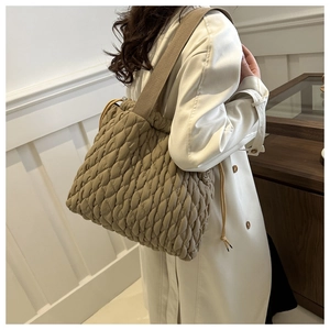 Detail der khakifarbenen Stepptasche mit flauschiger Textur und breitem Schultergurt
