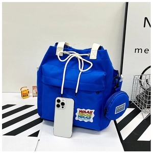 Close-up of blue canvas bucket bag with drawstring closure and small round coin purse