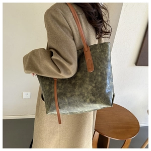 Close-up of vintage mottled faux leather texture and reinforced shoulder strap on tote bag
