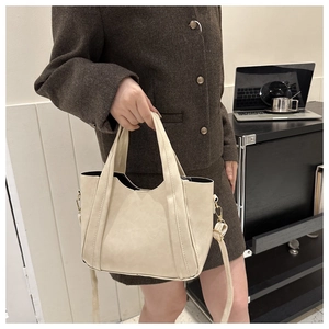 Cream white matte leather tote bag with dual handles and adjustable shoulder strap
