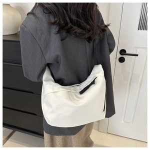 Detailed back view of a white nylon crescent tote bag worn as a casual shoulder bag