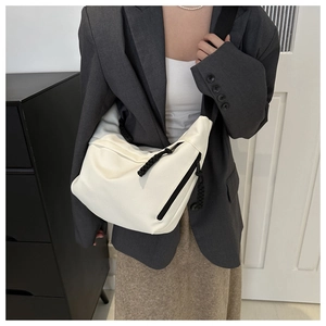 Detailed view of white nylon crescent bag featuring black woven rope zipper pull decoration