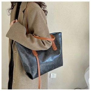 Side view of a vintage large tote bag in grey faux leather with brown slim shoulder straps