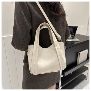 Model view of cream white PU leather tote bag with double handles and shoulder strap