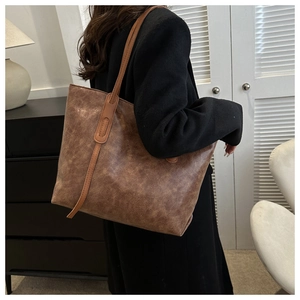 Close-up of vintage brown leather tote bag with large capacity shown on model shoulder