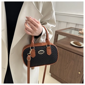 Detail of vintage quilted handbag with brown leather handles and YUBIYUAN metal logo