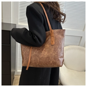 Detail view of the brown retro tote bag showing vintage cracked leather and long straps