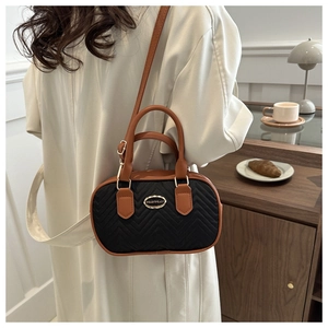 Retro black quilted baseball crossbody bag with brown leather trim and metal logo plate