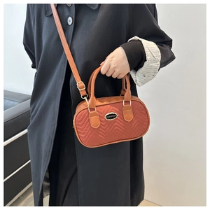 Retro orange quilted crossbody bag with golden hardware and brown leather handles