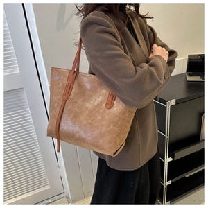 Side view of large vintage brown oil leather tote bag with stylish strap on shoulder