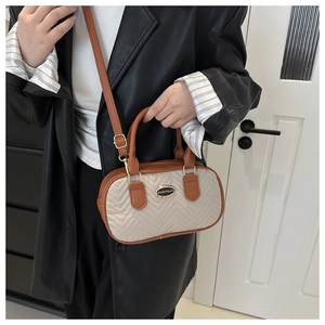 Detail of a mini quilted handbag in beige and brown with adjustable shoulder strap