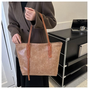 Detailed view of large vintage brown tote bag with oily leather texture and long straps